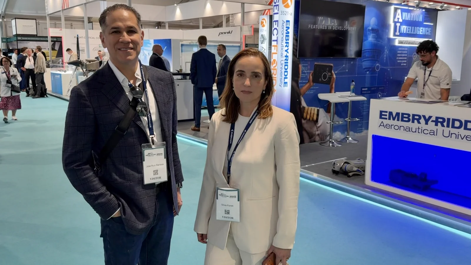 Jose J. Ruiz and Silvia Flores of Alder Koten on the Farnborough International Airshow show floor, near the Embry-Riddle Aeronautical University stand — Day 1, 20 July 2026.
